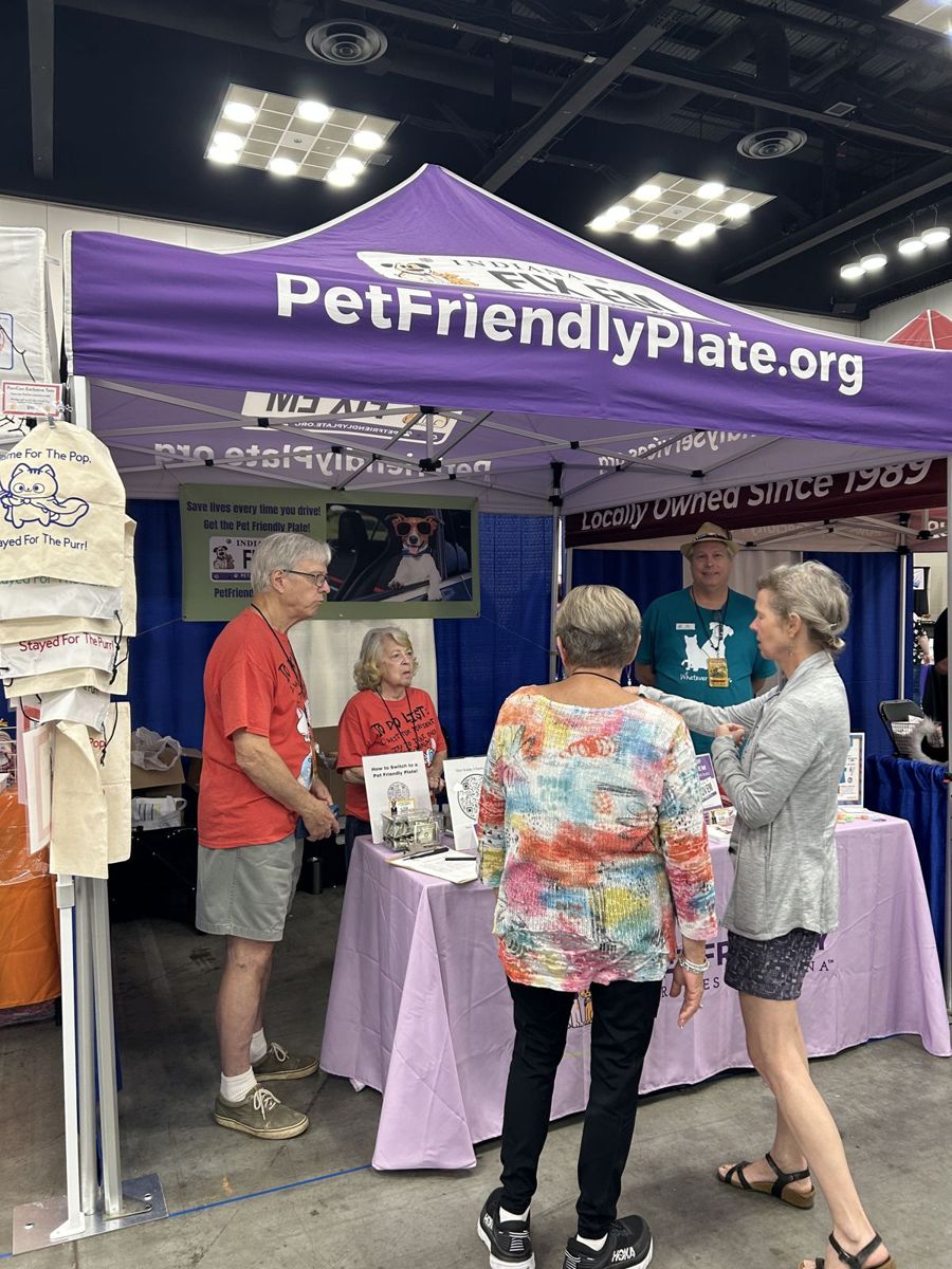 Attendees chatting with the PetFriendlyPlate.org team under their branded tent