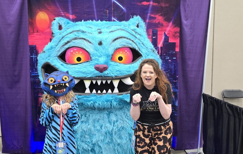 KJ and a young cosplayer posing with the giant blue cat photo op at PurrCon 2026