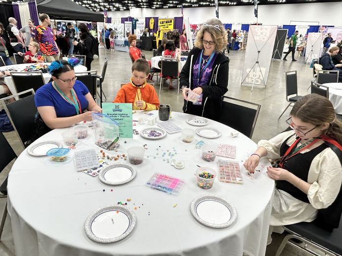 Families making crafts at the PurrCon activity tables