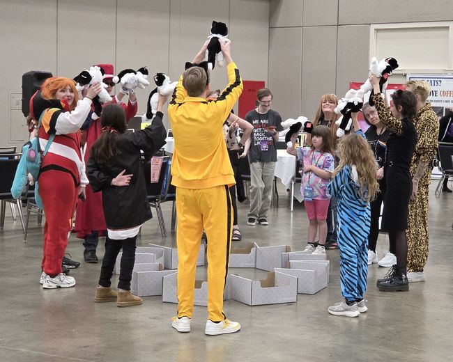 Players holding up plush cats during Musical Cat Boxes at PurrCon