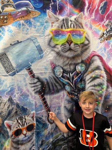 Young fan posing in front of a superhero cat mural