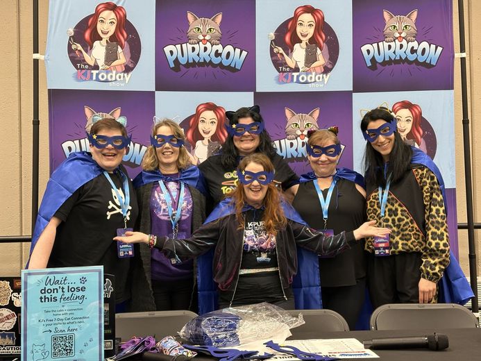 Group in masks and capes at the PurrCon backdrop