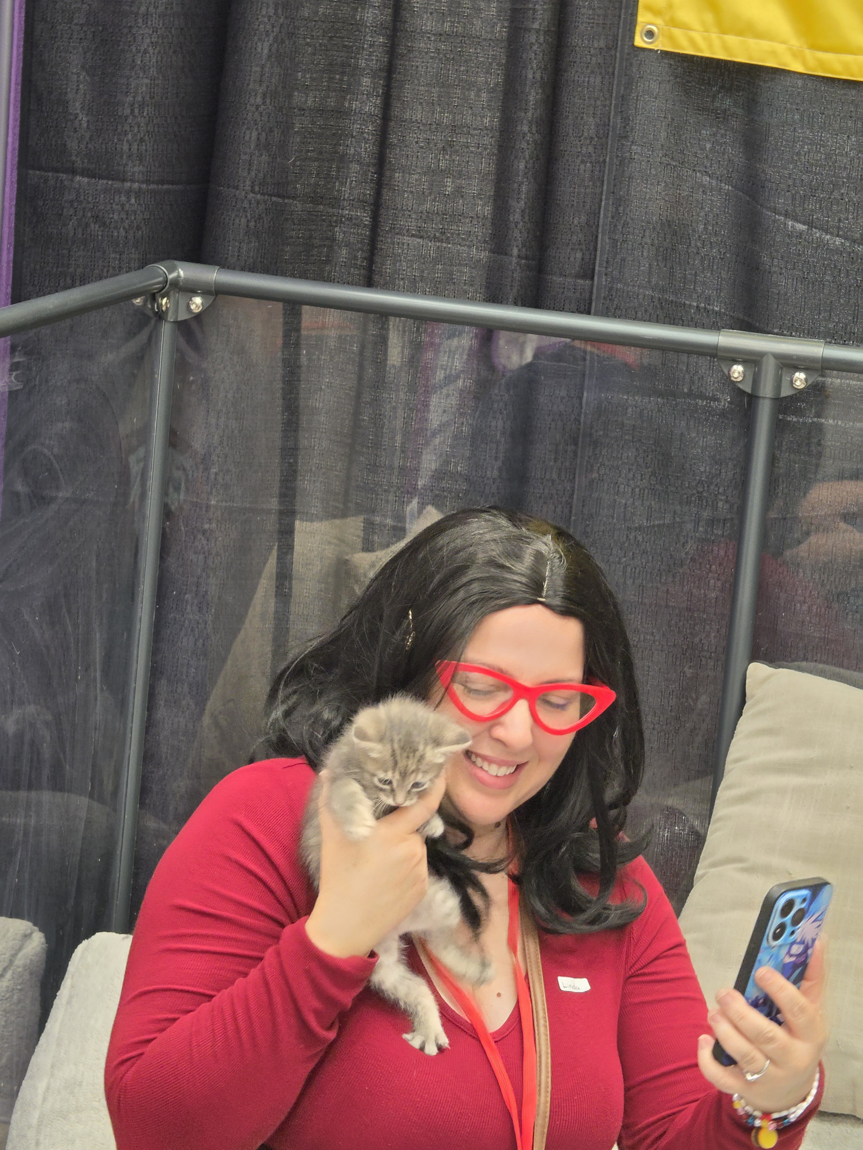 Attendee snuggling a kitten at a SuPURR experience